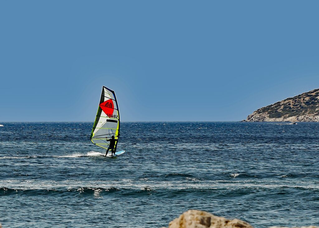 A windsurfer is out on the water on a sunny day.