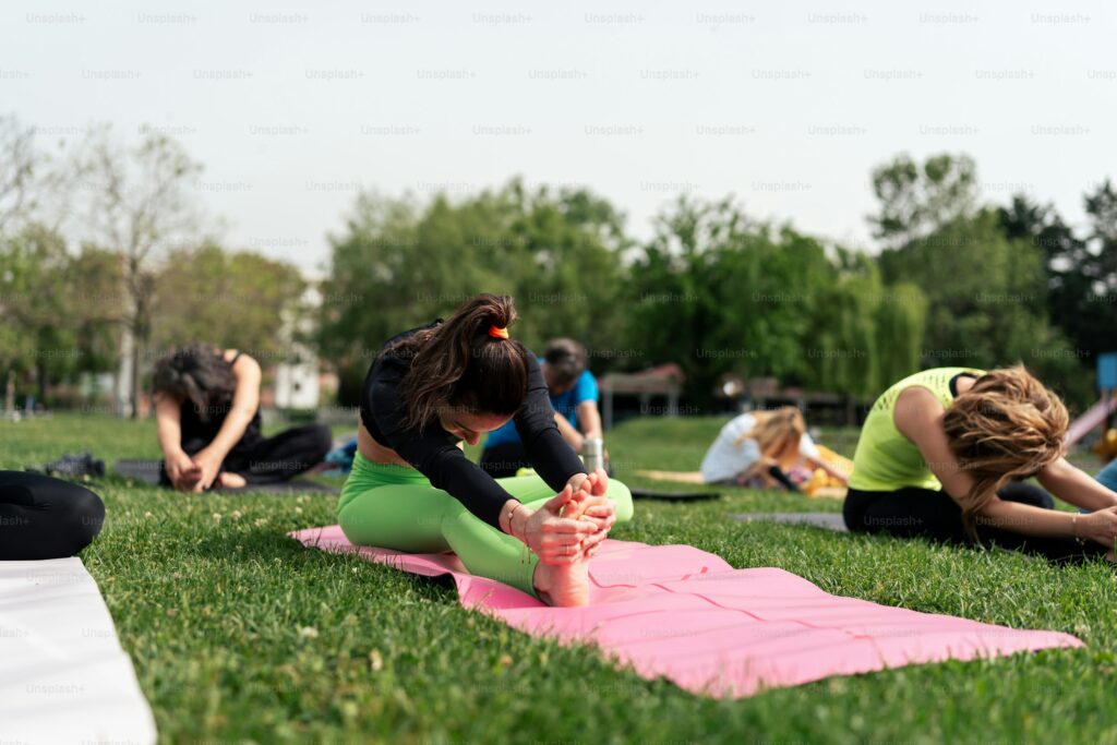 a group of people doing yoga in a park