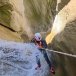 Canyoning in Greece with a guided rope descent through a gorge surrounded by natural scenery.