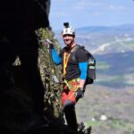 Συμμετέχων σε οργανωμένη Via Ferrata στα Μετέωρα με κράνος, εξοπλισμό ασφαλείας και εντυπωσιακό βραχώδες τοπίο.